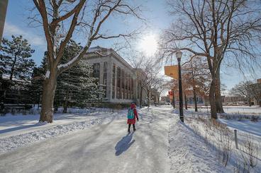Student walk along Northrop Mall in the winter